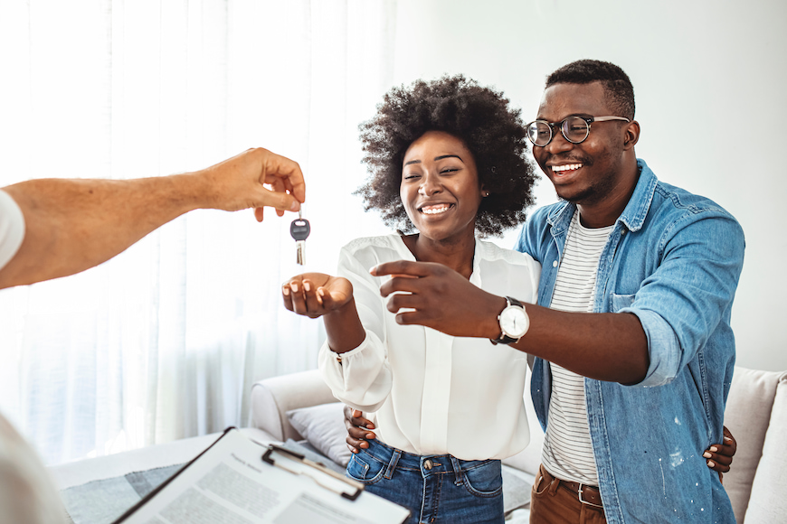 A young couple being handed the keys to new build before they move in.