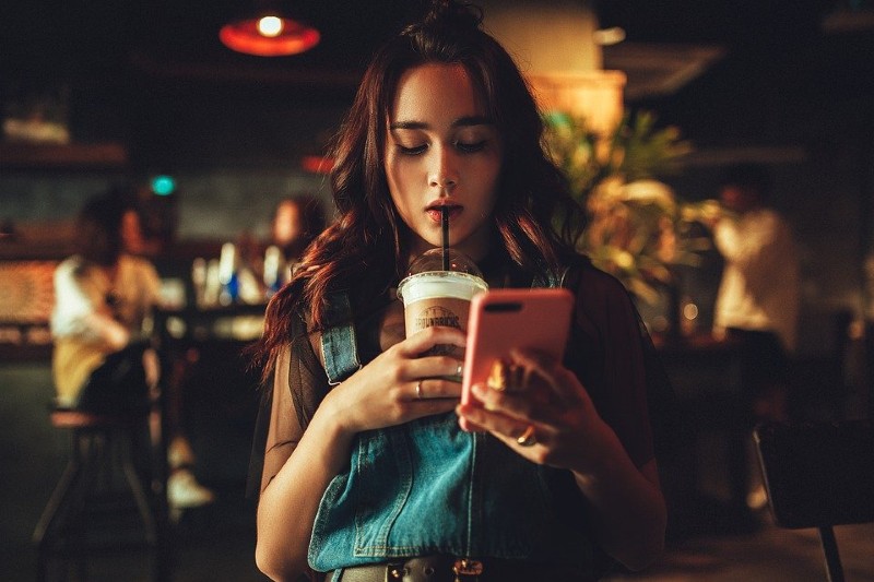 girl drinking coffee with smartphone