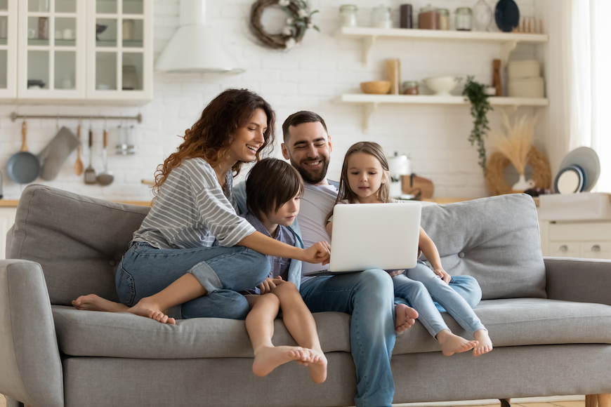 Family gathered around a laptop with post paid family plans